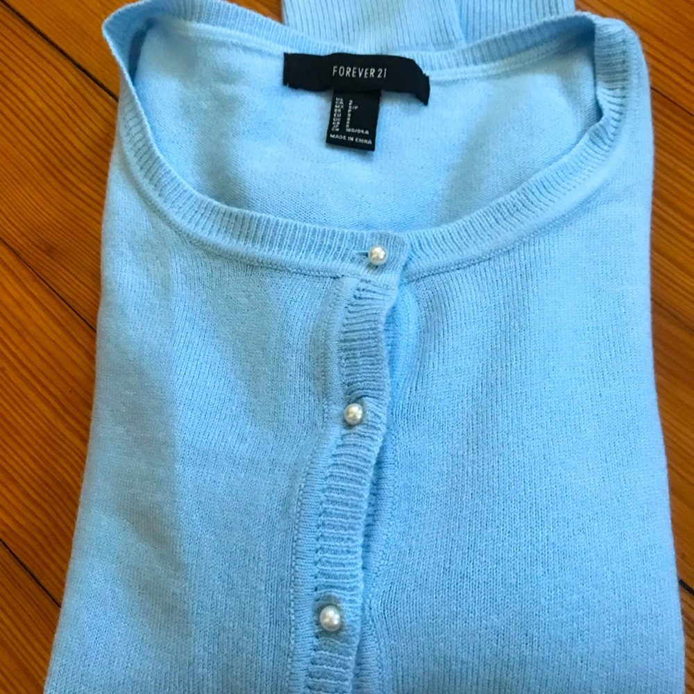 Baby blue very soft sweater with pearls buttons .